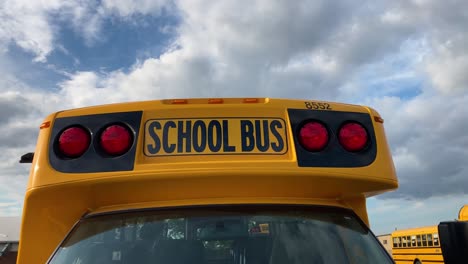 círculo de cierre del autobús escolar a la derecha que muestra luces rojas en el estacionamiento de la escuela