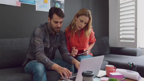 Male-and-female-executives-working-together-on-laptop-in-a-modern-office-4k