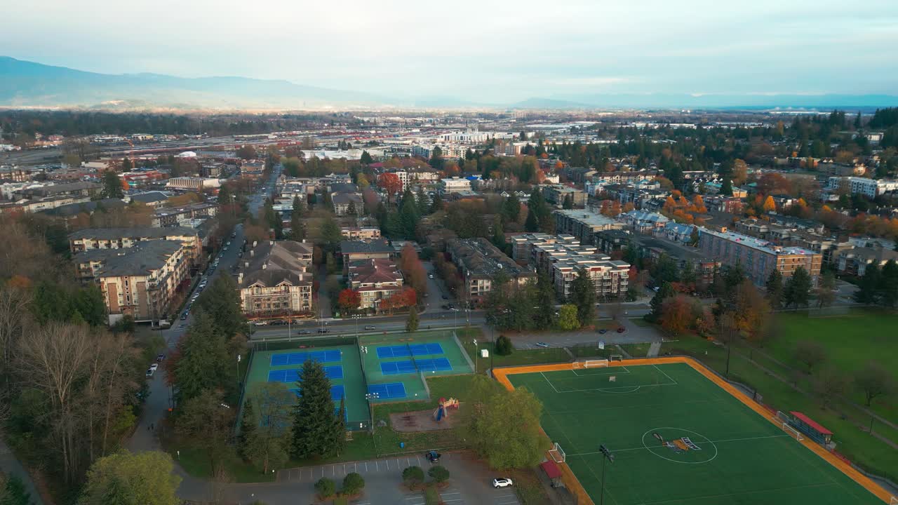 A drone shot of a basketball field, tennis field and playground in gate's park.