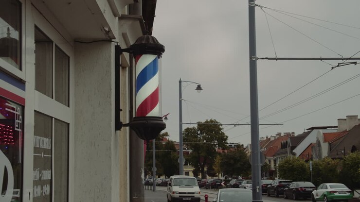 Insegna da barbiere che richiama la gente per strada.
