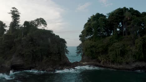 drone passed between the two islet with trees and reveal beautiful seascape in costa rica