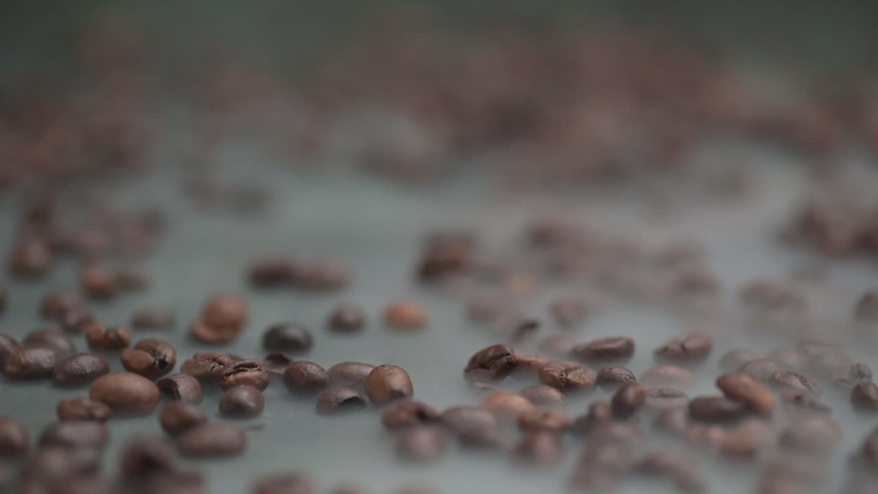 Primo piano con allontanamento attraverso i chicchi di caffè fumanti