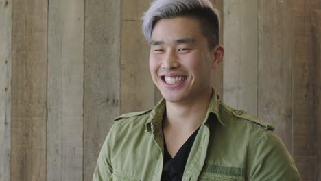 유행의 패션을 입고 행복하게 웃고 긍정적인 라이프 스타일을 즐기는 젊은 즐거운 아시아 남자의 초상화
