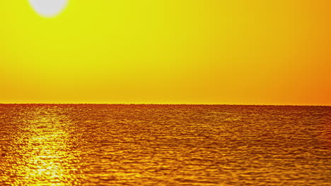 reflejos brillantes del sol en el agua con un atardecer naranja