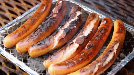 grillando salchichas en una parrilla de barbacoa desechable.