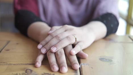 woman's hands resting on a table