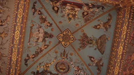 roatating shot of the colorful religious paintings and carvings on the interior of the archway of patuxai victory monument in the center of vientiane, laos