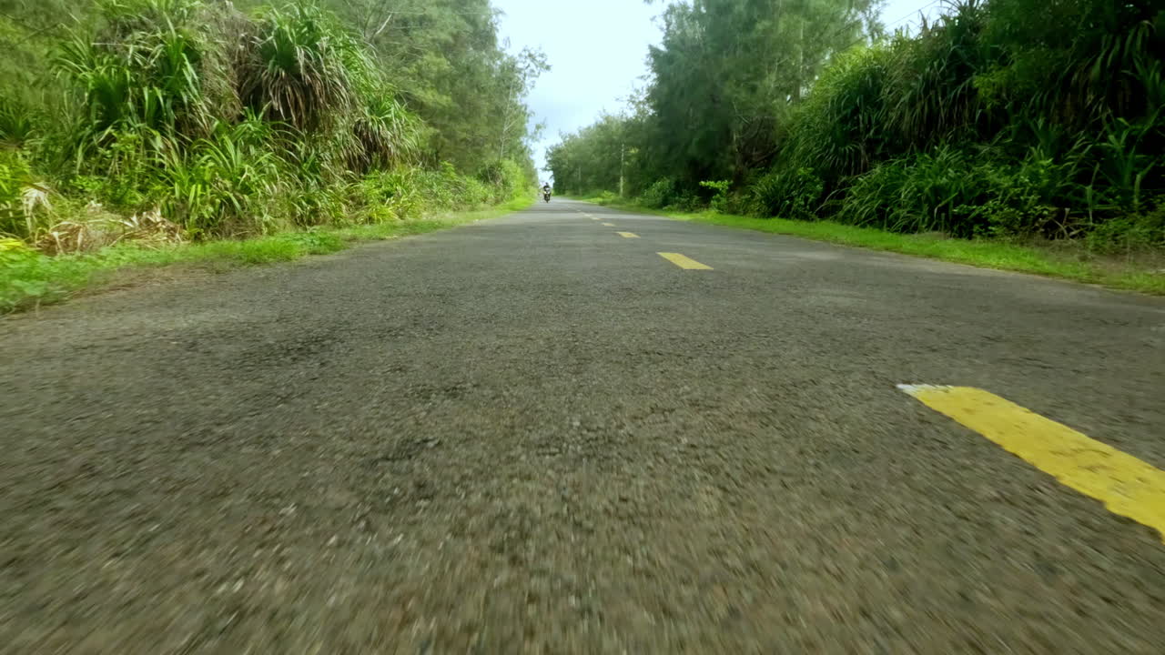 cámara de acción de bajo ángulo pov conduciendo rápido en la carretera de asfalto seguido por scooter motocicleta en la carretera del campo