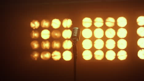 Vintage-microphone-standing-empty-stage-in-nightclub.-Retro-mic-placed-on-scene