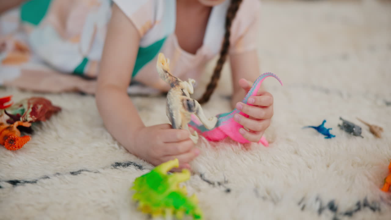 Premium stock video Girl, play and dinosaur toys on floor with animals