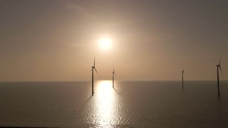 flyover wind turbines seascape and bright sunlight reflection on water surface