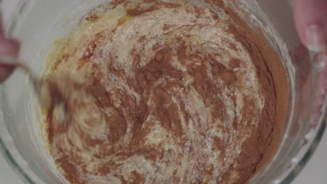 mezclando canela y extracto de vainilla en masa amarilla, primer plano desde arriba