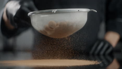 chef sifting cocoa powder over truffles