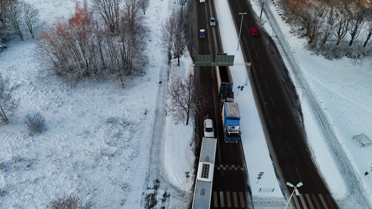 Busy winter intersection, aerial view of traffic and snowy roads