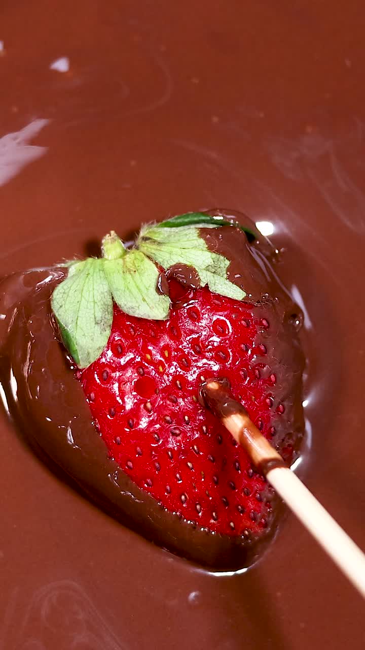 녹은 초콜릿 에 딸기 를 담그고 있는 것