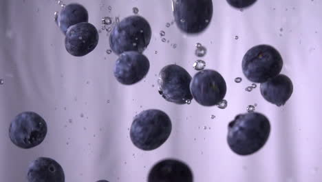 blueberries falling in water with white background, 120fps slow-motion blueberry fruit falling in a water tank