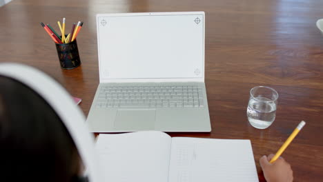 Biracial-girl-having-elementary-school-class-on-laptop-with-copy-space-on-screen,-slow-motion