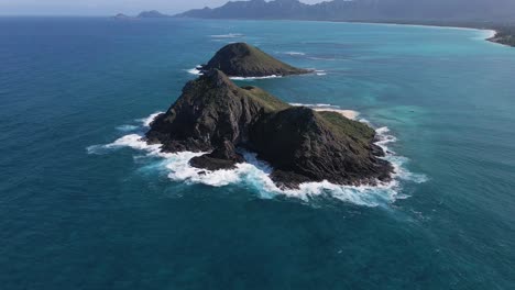 wellen brechen auf mokulua rocky island, hawaii