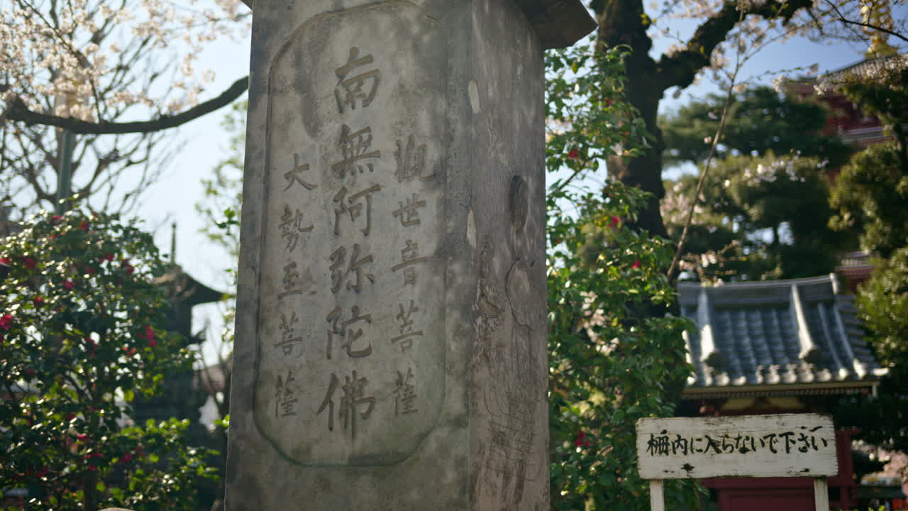 Close up of a stone pillar in the courtyard of the Senso-ji temple in Asakusa, Japan. Translation: "Namo Amitabha"