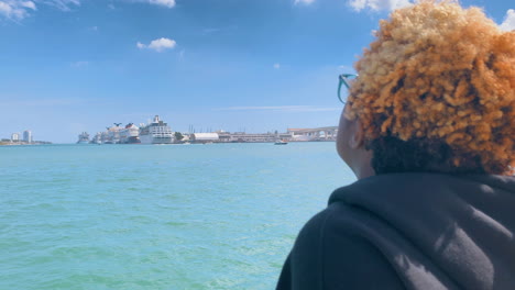 african american girl watching the clouds and ships on the pier