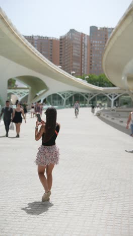 woman taking photo in a city park with bridges