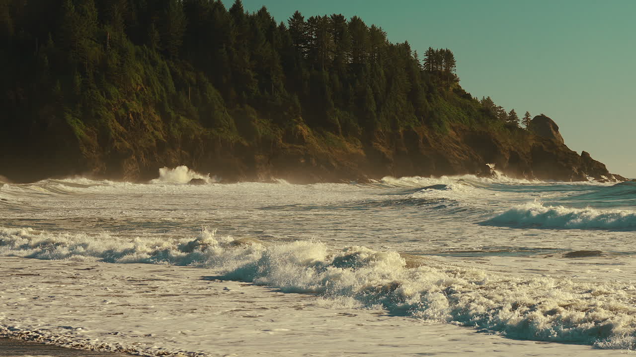Rushing Waves Over Foamy Sea Surface With Rocky Cliffs Background During Sunrise