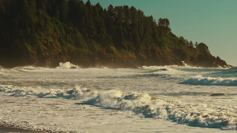 Rushing-Waves-Over-Foamy-Sea-Surface-With-Rocky-Cliffs-Background-During-Sunrise