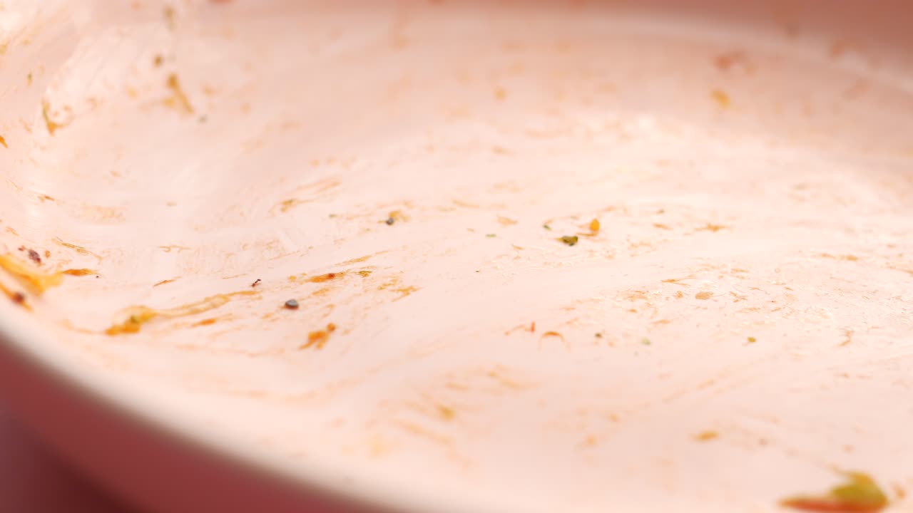 plato rosado vacío con residuos de alimentos