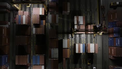 aerial view of an efficient container terminal operations with cranes moving cargo containers in a busy port environment during nighttime