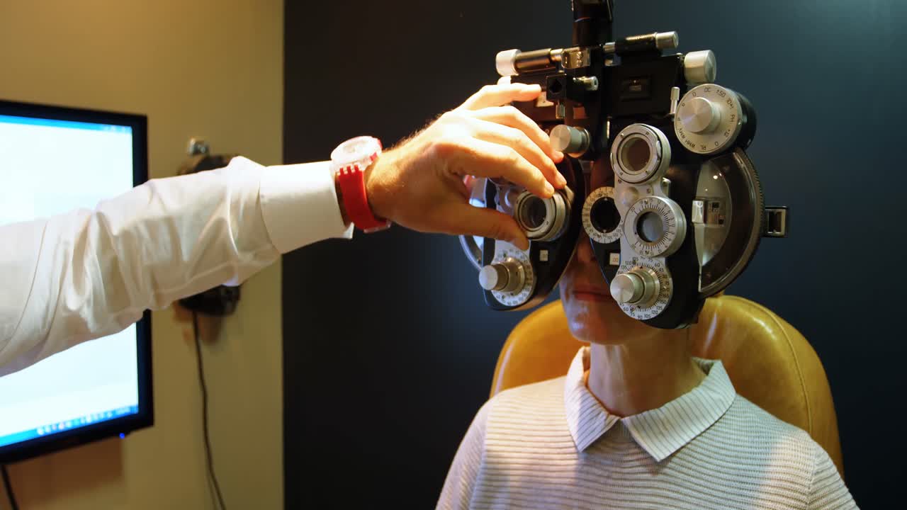 Optometrist examining patient eyes with phoropter 4k