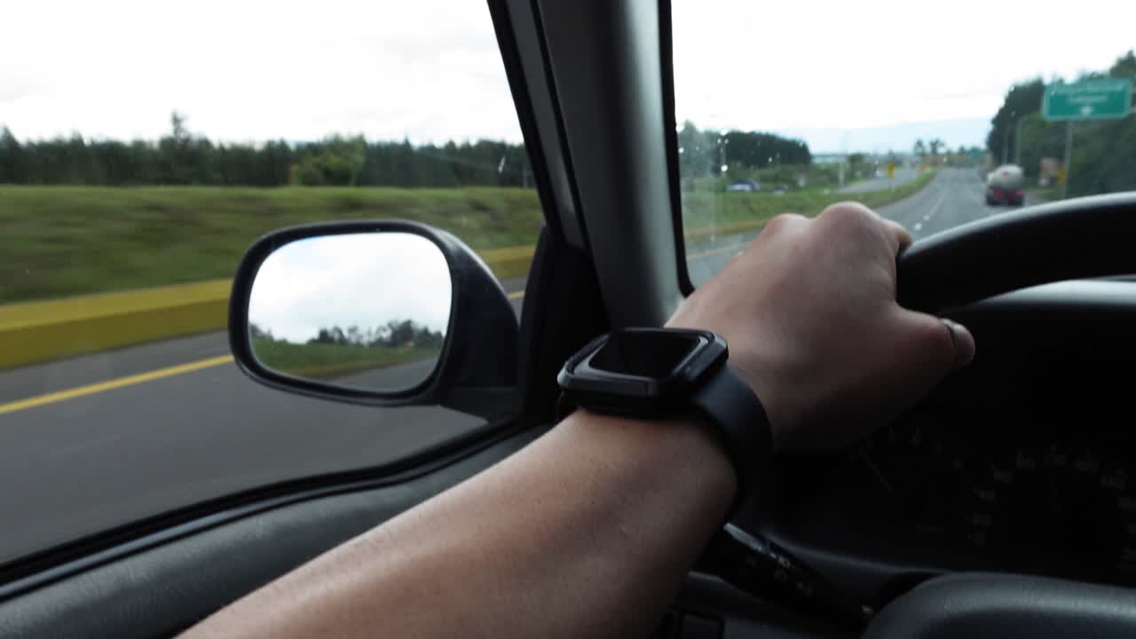 Close-Up Hand on Steering Wheel Driving on Interstate Highway