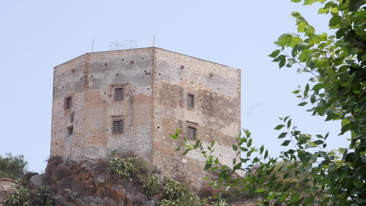 Torre di Vélez de Benaudalla a Granada. L'architettura difensiva in pietra, le antiche finestre con inferriate e le mura medievali sono ben visibili.