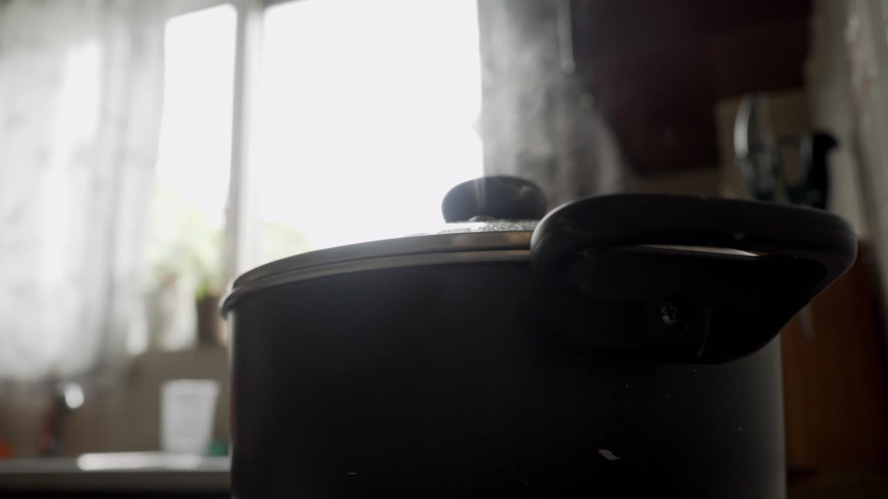 검은 수프 냄비, 낮은 각도, 배경 4k의 창에서 나오는 밝은 빛에서 나오는 증기에 가까이