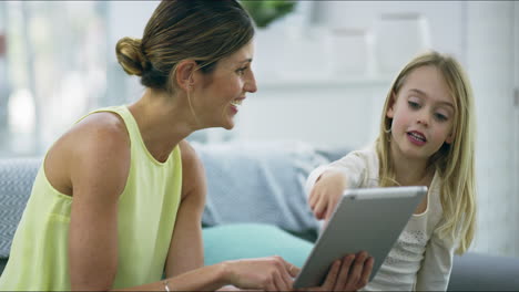 a mother and her little daughter using a digital