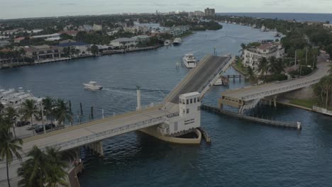 Aerial-orbital-shot-moving-around-bridge-while-its-rising-to-allow-oncoming-traffic