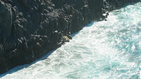 foamy atlantic ocean waves hitting rocky coast of tenerife island, slow motion