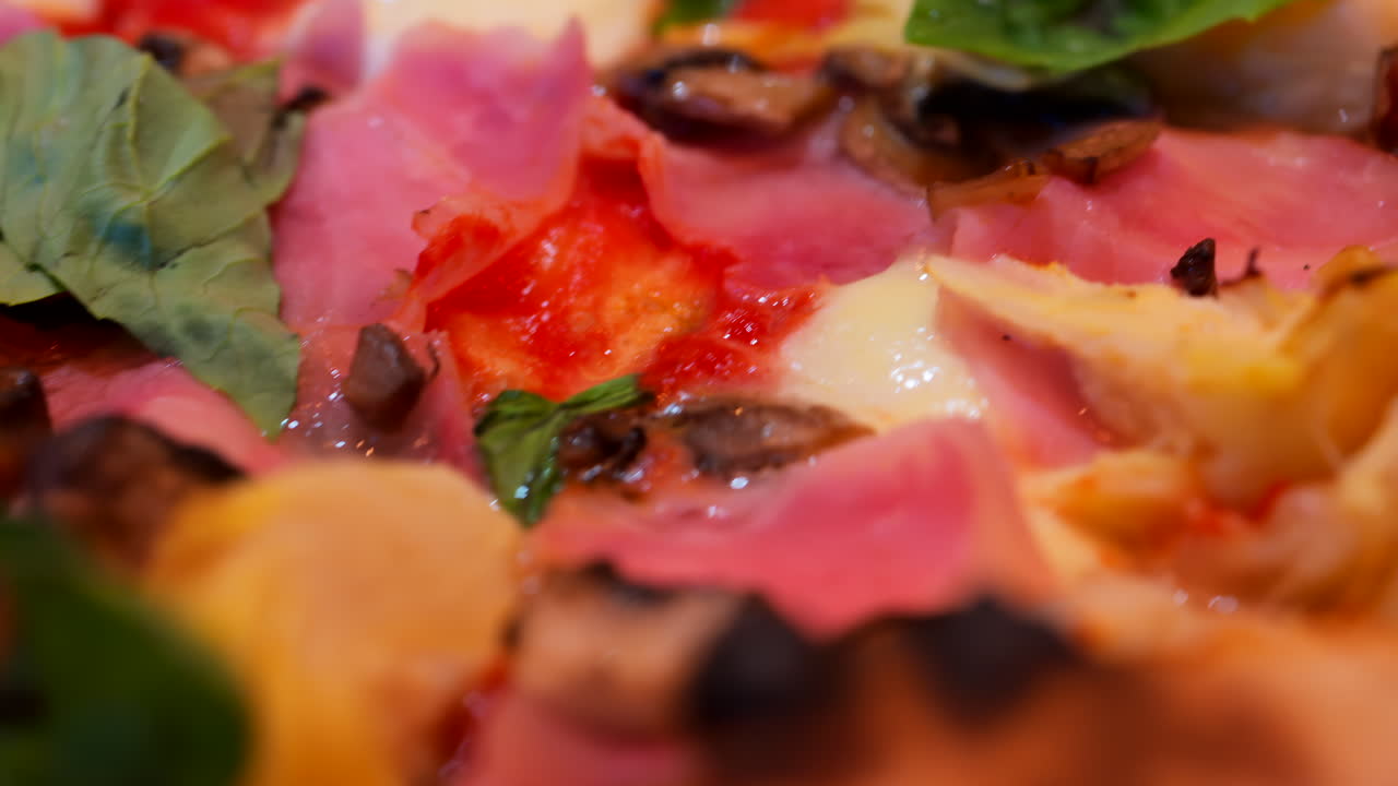 Close up of pizza with artichoke, ham, mushrooms and basil