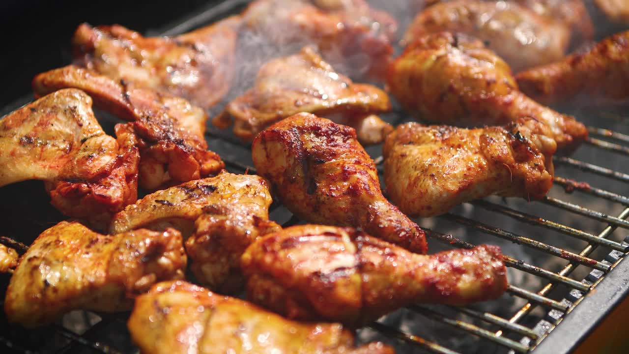 Delicious chicken pieces frying on barbecue grill