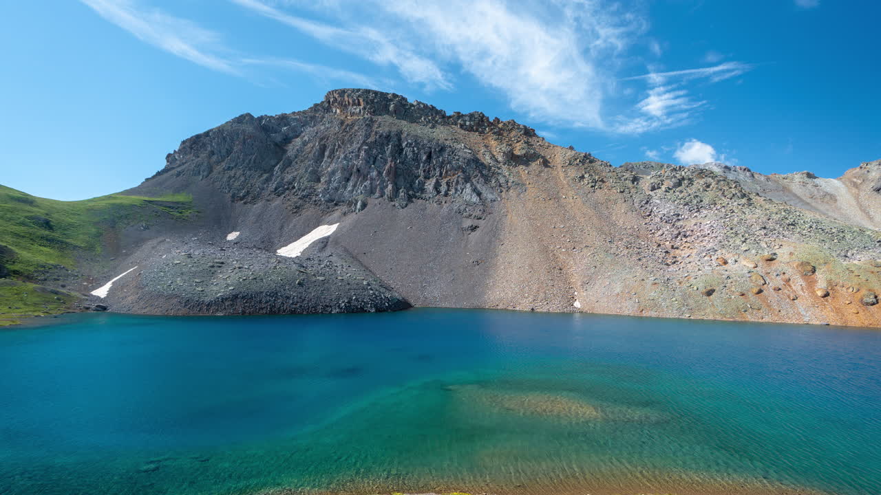 에메랄드 빙하 호수 물과 산봉우리 위로 움직이는 구름과 그림자의 시간 경과