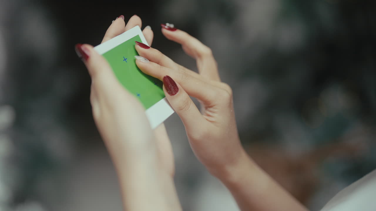 Woman holding a green screen instant photo