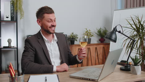 Businessman-make-video-call-conversation-on-laptop-celebrate-successful-contract-drinking-champagne