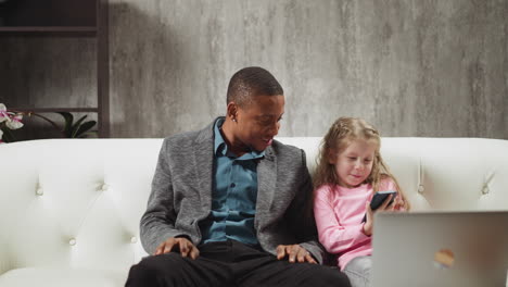 little girl watches cartoons on phone sitting with teacher