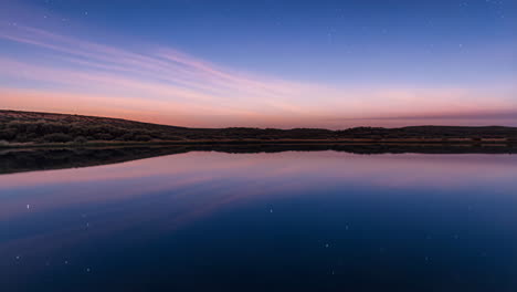 starry night sky reflected in a tranquil lake landscape