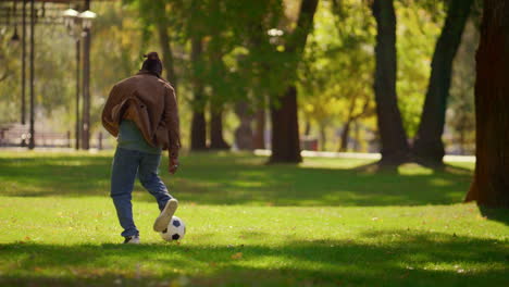 Hombre-Jugando-Fútbol-En-El-Parque-En-Un-Cálido-Día-De-Primavera.-Jugador-Concentrado-Practicando-Al-Aire-Libre