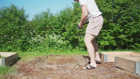 man placing under bed grass control mats on the soil for garden raised bed