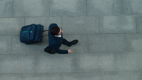 top view businessman walking with suitcase. man going on business trip outdoors