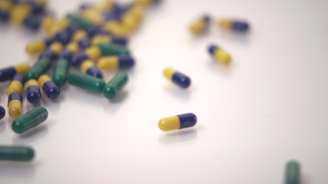 macro de cámara lenta de variedades de píldoras caídas sobre fondo blanco