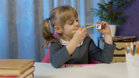 Niña-Haciendo-Tarea-Escolar-Enseña-Letras-Del-Alfabeto-Con-El-Maestro-En-Casa,-Videollamada-Por-Webcam