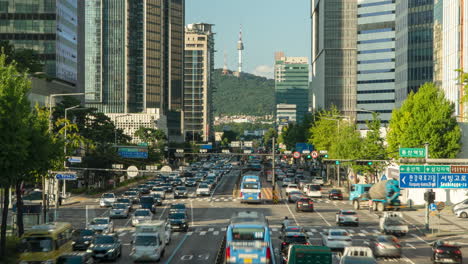 Zeitrafferverkehr-Tagsüber-Im-Stadtzentrum-Von-Seoul,-Bezirk-Yongsan,-Blick-Auf-Den-Namsan-Turm-Und-Hohe-Wolkenkratzergebäude-An-Sommertagen