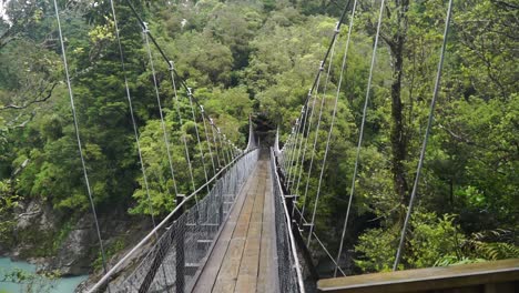 slowmo - swing bridge over blue glacier river at hokitika gorge, south island, new zealand